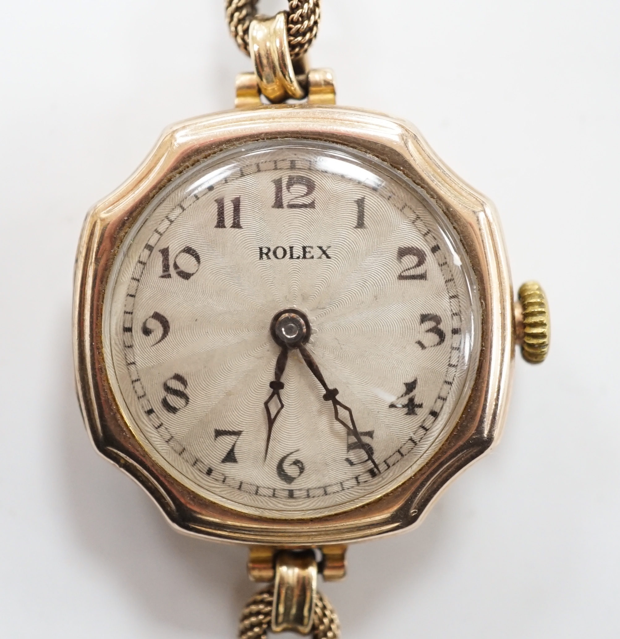 A lady's 1920's 9ct gold Rolex manual wind wrist watch, with sunburst Arabic dial, on a 9ct twin strand Vertex bracelet, gross weight 18.8 grams.